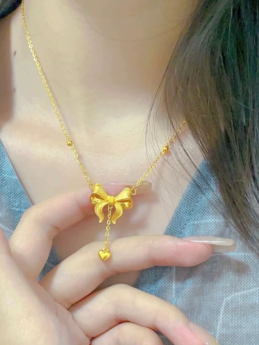 Collana con pendente a cuore e fiocco con nappe dorata_voghion.com