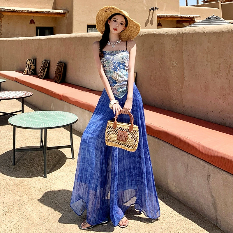 Летний костюм для женщин в стиле морского курорта: топ-бюстье синего цвета с принтом и широкие брюки с эффектом размазывания.