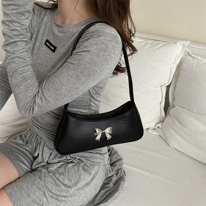 Bolsos axilales de alta textura 2024 verano nuevo diseño de moda francesa temperamento simple arco bolso de hombro