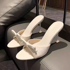 涼しげな女性の夏の外は2025の新型の1字を着てアンドロメダのファッションの蝶結びのスリッパのサンダルのハイヒールを引っ張ります。