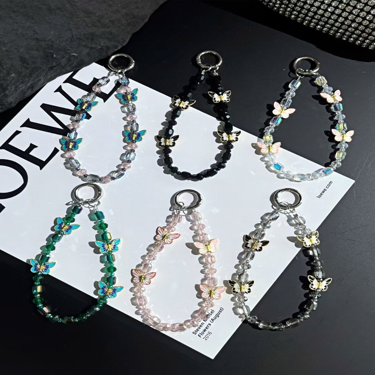 Cadena de teléfono móvil al por mayor cadena de cuentas de cristal flor de mariposa sentido de alta gama cadena corta hecha a mano para mujer bolsa de viento NIS todo fósforo