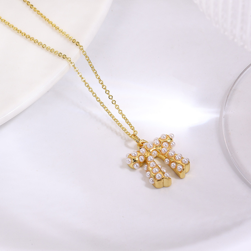 ヨーロッパとアメリカのファッショナブルな銅メッキ 18K 象嵌模造パールリボンネックレスペンダントイヤリング 3 点セット装飾|undefined