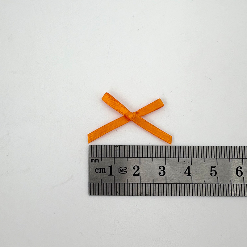 1つのベルト機は現物の蝶結びをします。3mmのポリエステルリボンの蝶結びのブラジャーの下着はカードを飾って包装します。