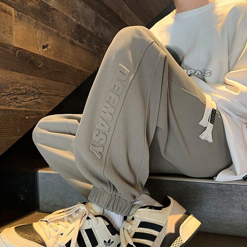 Steel-stamped letter-printed ankle-banded sweatpants for men—autumn/winter loose-fitting, wide-leg casual pants; pineapple-patterned sports pants in Japanese style.