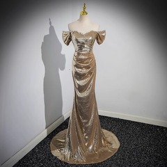 金色のタキシードの女性の高級感の司会者の肩の尾のスパンコールの美しい声の独唱の声楽の芸はドレスのスカートを試験します。