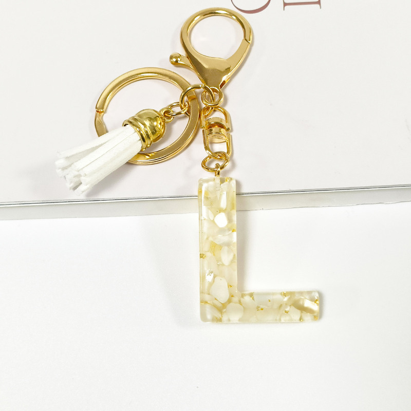 越境新商品の貝殻石に金箔のアルファベットのキーホルダーをつけます。|undefined