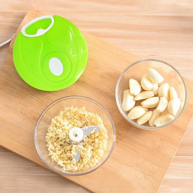 手動の野菜切り器の手で縄を引いてニンニクを切る器はニンニクをいじります。|undefined