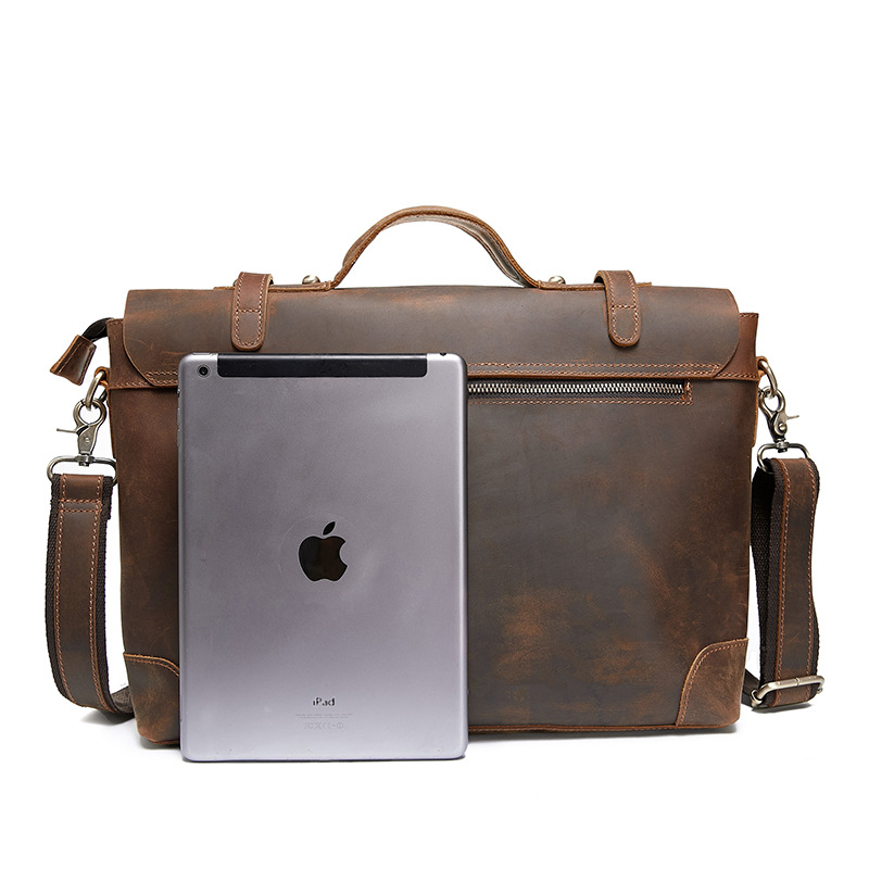 欧米のレトロな本革の男性はブリーフケースを持っています。