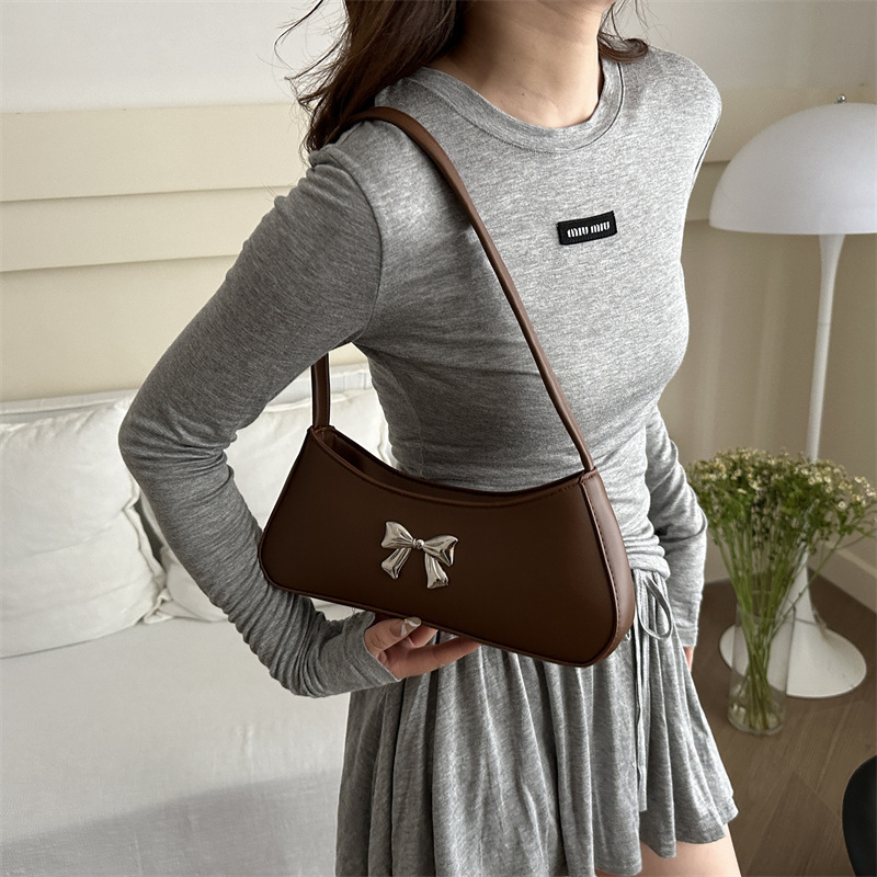 Bolsos axilales de alta textura 2024 verano nuevo diseño de moda francesa temperamento simple arco bolso de hombro