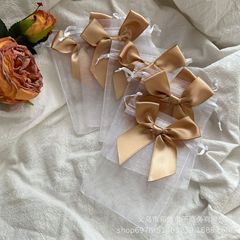クロスボーダーの白い蝶結びのガーゼの袋の結婚式のキャンディーの袋のパーティーの贈り物の袋の贈り物の包装袋の紐を引きます。