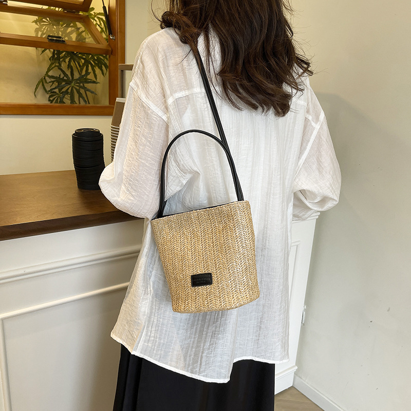 Bolso de cubo de vacaciones junto al mar 2025 nuevo bolso de mujer bolso de hombro tejido de paja de playa bolso de mensajero de color de contraste a rayas