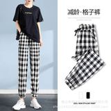 Эластичные черно -белые брюки клетку ткане