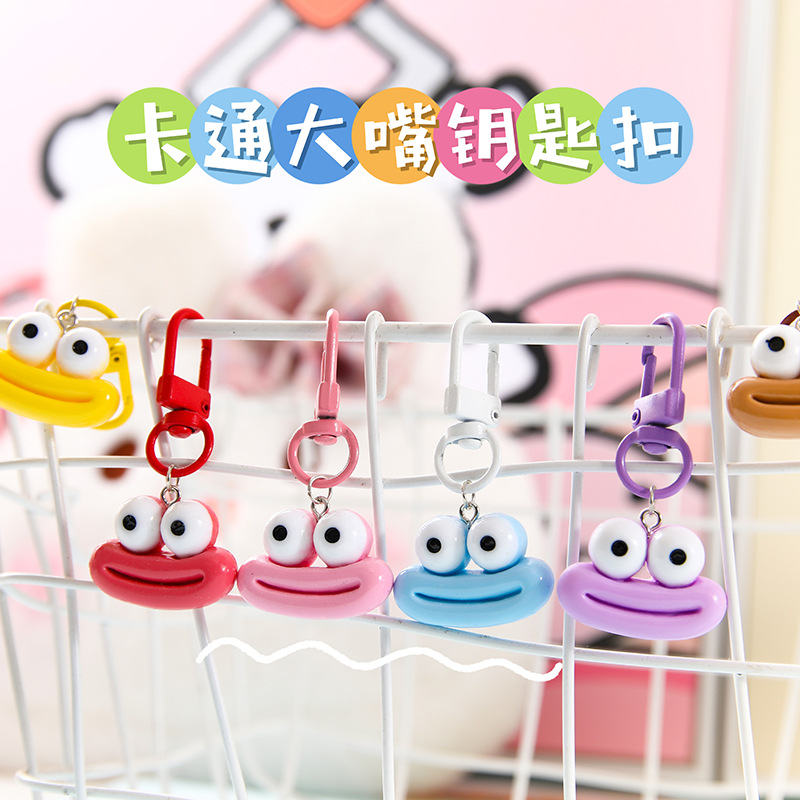 かわいいアニメの大きな口のキーホルダーは学生のカバンを飾っています。