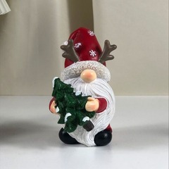 クリスマスの祝日のデスクトップの装飾はプレゼントを抱いて木のサンタクロースの樹脂の工芸品の家庭の寝室の客間を抱いて贈り物をします。