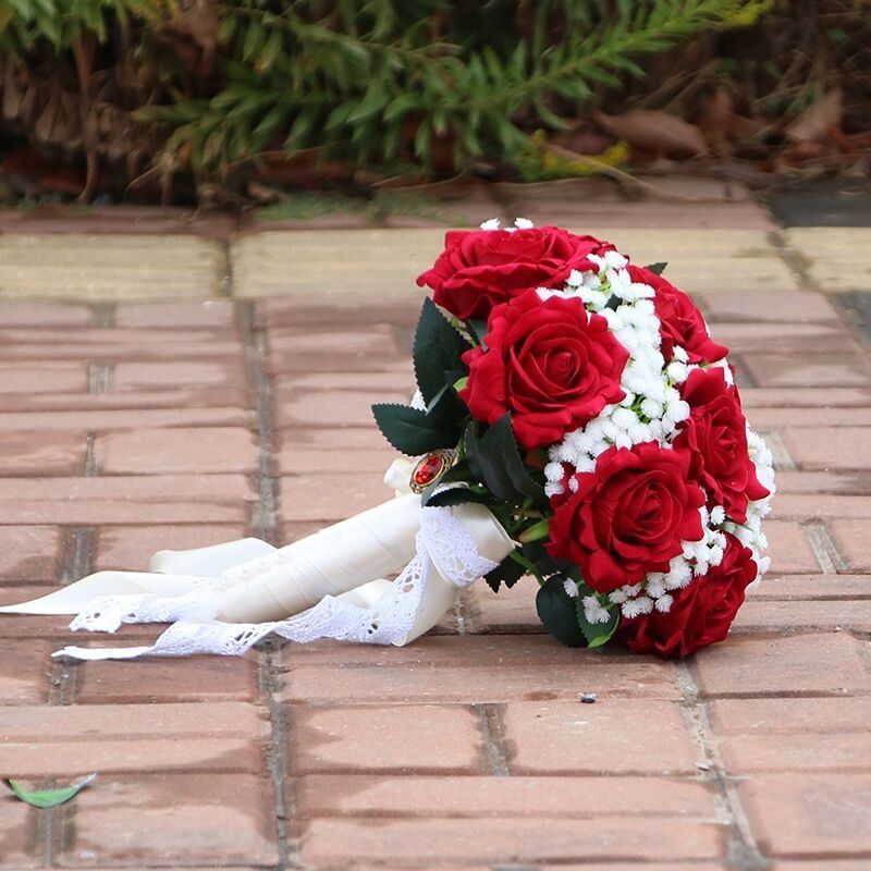 手に花を持つ新婦の韓国式結婚式の領収書のシミュレーションの花束の森系のウェディングドレスの撮影の道具の手に花をささげます。|undefined