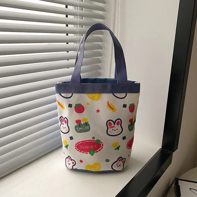 かわいい落書きバケツバッグinsプリント円筒バッグキャンバス弁当袋韓風少女は弁当箱を持っています。|undefined