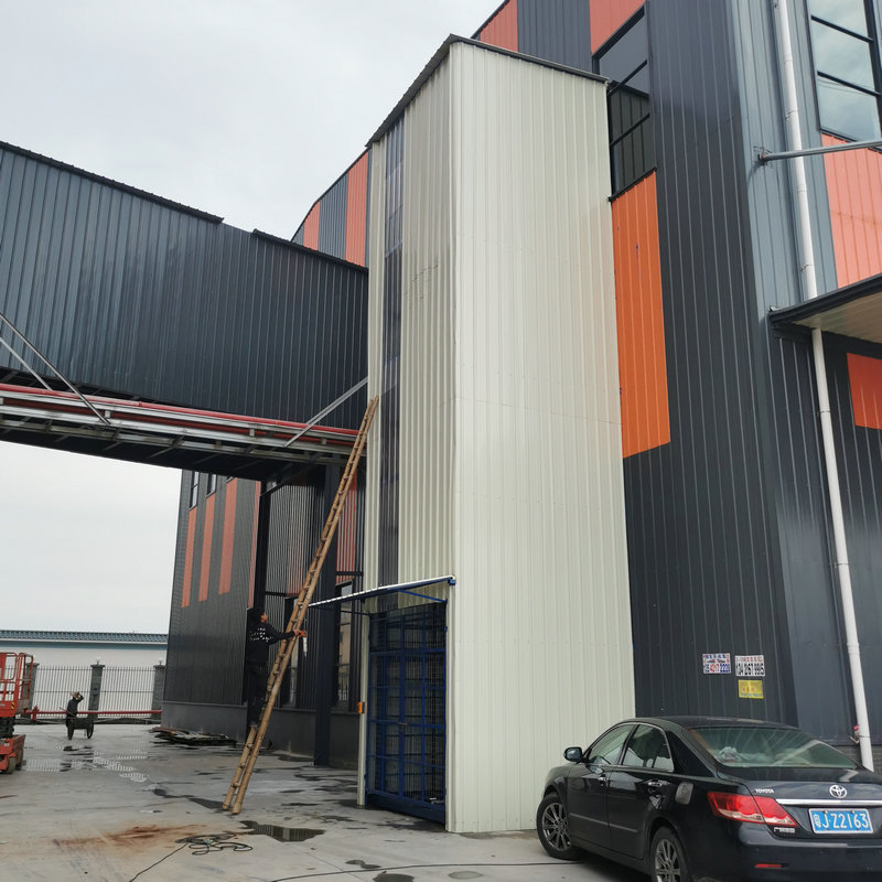 Elevador de Riel para Transporte de Mercancías en Exteriores de Fábrica, Plataforma Elevadora Hidráulica Fija con Azulejos de Colores, Alta Capacidad de Carga.