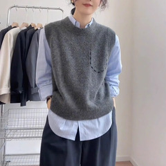 高級感のある灰色のニットベストの女性は秋冬に保温セーターを重ねて着ます。
