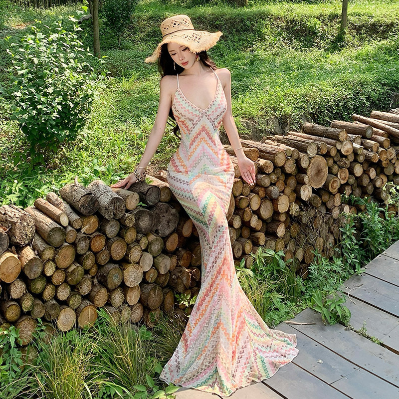 Bohemian-style maxi dress with a V-neck, sleeveless design, cinched waist, and a figure-hugging, fishtail silhouette