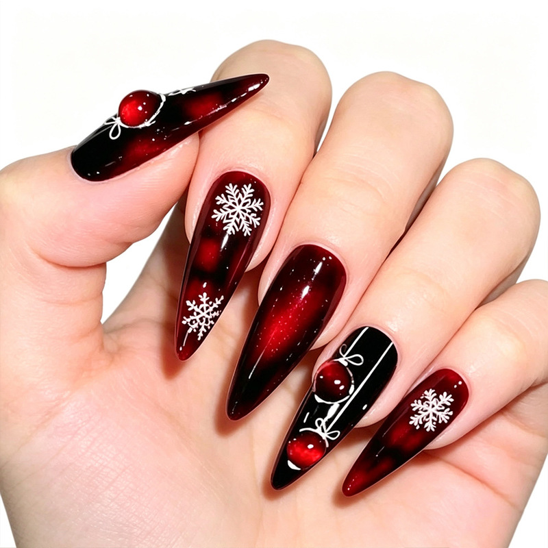 Nail patches in cool Christmas red and black plaid with white snowflakes, Christmas balls, and long, pointed almond-shaped wearable nail pieces