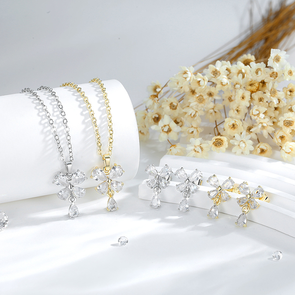 Exquisito conjunto de adornos de flores de cuatro hojas de diseño de moda transfronterizo cobre chapado en oro 14K colgante de flores de zircon aretes