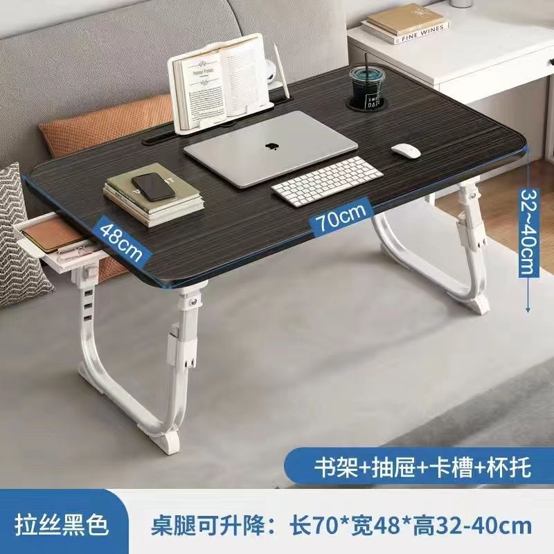 ベッドの上の小さい机のノートパソコンの机の上で折り畳みます。|undefined