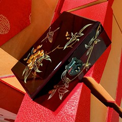 手作りの漆の絵の首飾りの箱のお土産は金彩の絵を貼ります。