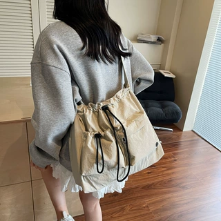 帆布包女大学生2025新款秋冬百搭抽绳单肩斜挎包高级感通勤托特包