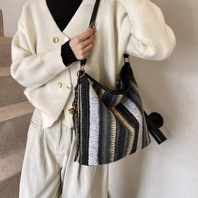 Bolsa de cubo de tendencia coreana a rayas, bolsa de hombro de gran capacidad, otoño y invierno 2025, nueva bolsa de mochila casual para mujeres.