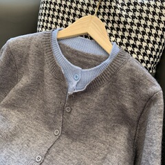 客票 ~ 偽の2つの色合わせの単列は丸首のニットのカーディガンの女性の秋の灰色の優しさの外でセーターのコートを掛けます。