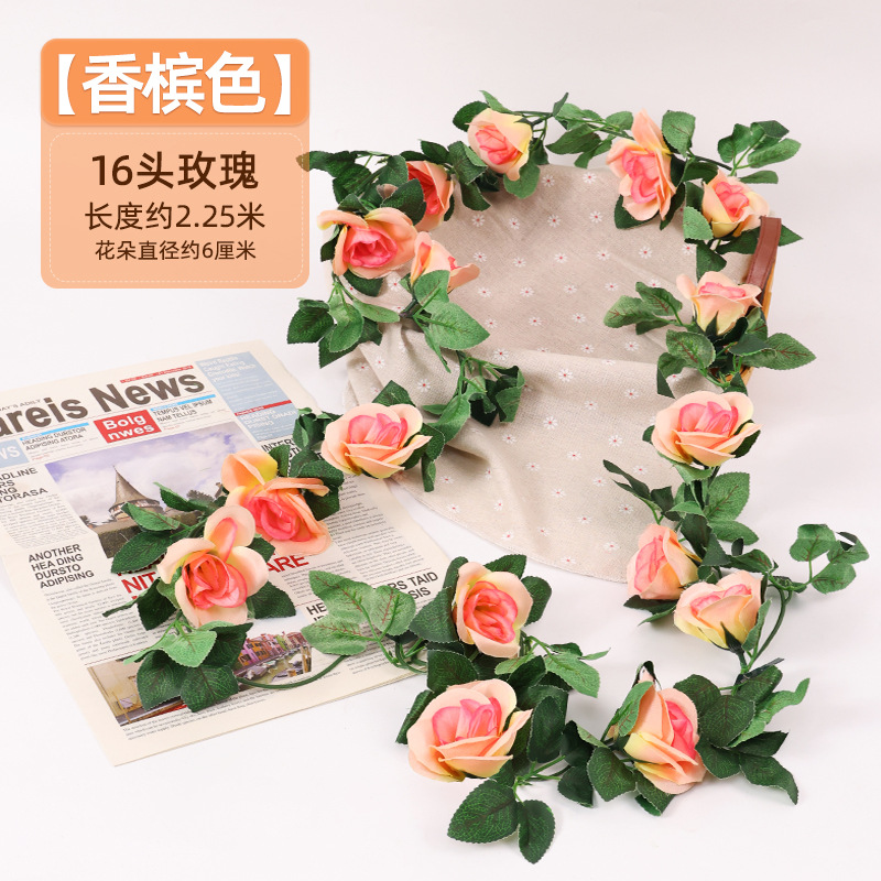 Simulación de flores falsas rosas de caña colgando la pared tubería de drenaje envuelta hoja verde que cubre la parte superior de la decoración de boda de plástico