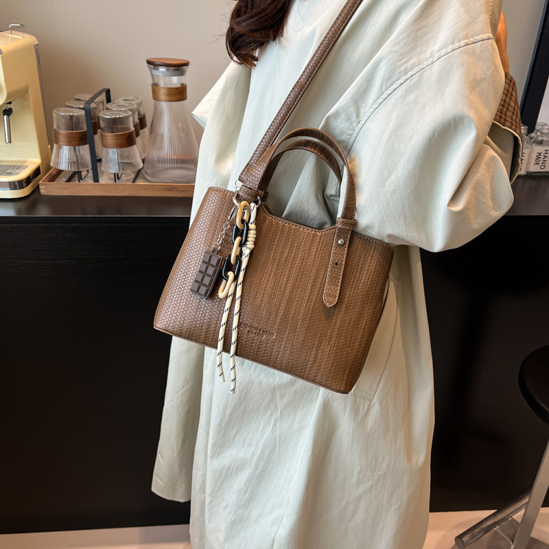 Texturas casuales bolsas de mano para mujeres otoño y invierno 2025 nueva moda simple bolsas de hombro versátiles retro mochila