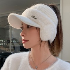 暖かい空の帽子の女性は秋冬にポニーテールをして野球帽を編みます。