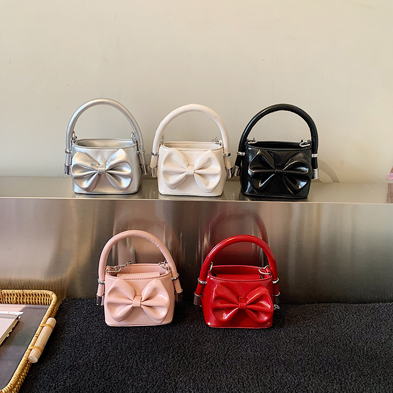 Nuevos bolsos de cadena coreanos para niños y niñas, bolsos de mini arco, bolsos de mano para niños, bolsos de comercio exterior transfronterizos