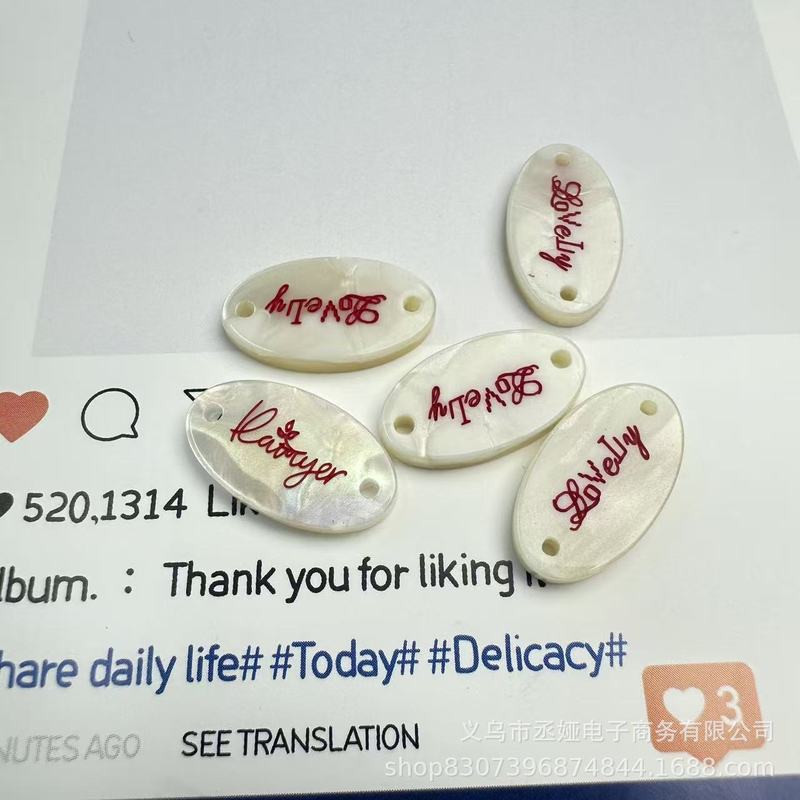 现货仿贝树脂商标吊牌字母椭圆蝴蝶结衣标高端百搭装饰纽扣60款|undefined