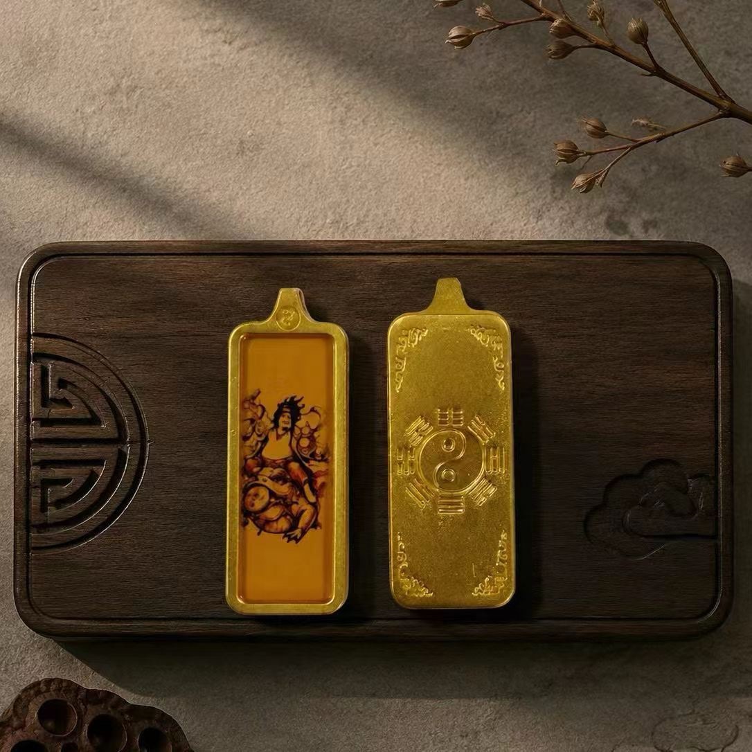 Tangka pendant with the motif of the golden toad playing with the hair. Hand-painted gold-painted Tangka pendant with the motif of the golden toad playing with the hair