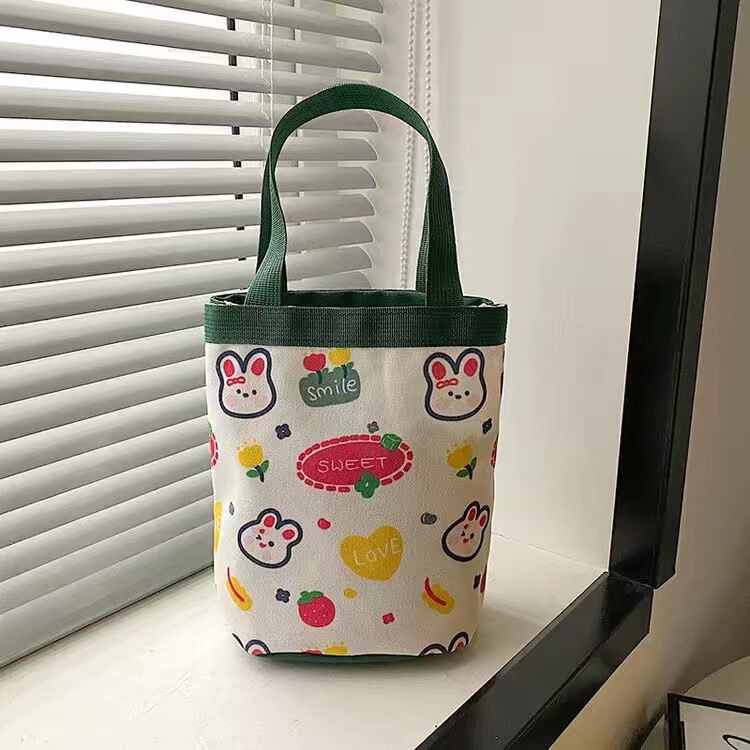 かわいい落書きバケツバッグinsプリント円筒バッグキャンバス弁当袋韓風少女は弁当箱を持っています。|undefined