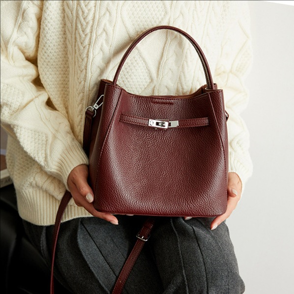 Bolso coreano de cuero suave litchi de gran capacidad de un solo hombro bolso de cubo 2025 nuevo bolso de cinturón de bloqueo para mujeres