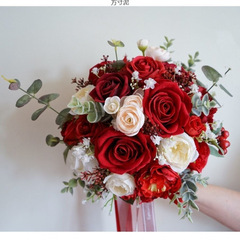 手に花の新婦をささげて結婚します。赤いバラの新型の森系の結婚式は花の写真を撮って道具を撮影します。