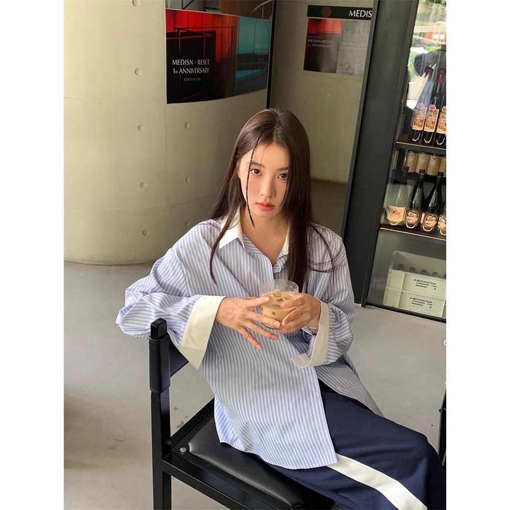 青と白のストライプは色の長袖のシャツの女性にぶつかります。