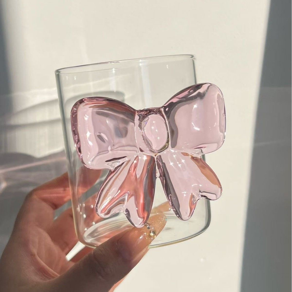 Bicchiere da caffè, succo, vino e cocktail rosa con fiocco, carino e di alta qualità._voghion.com