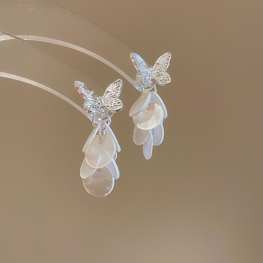 Pendientes de borla de concha blanca redonda con aguja de plata Pendientes de todo fósforo de moda de estilo de vacaciones Pendientes de alta gama de nicho al por mayor