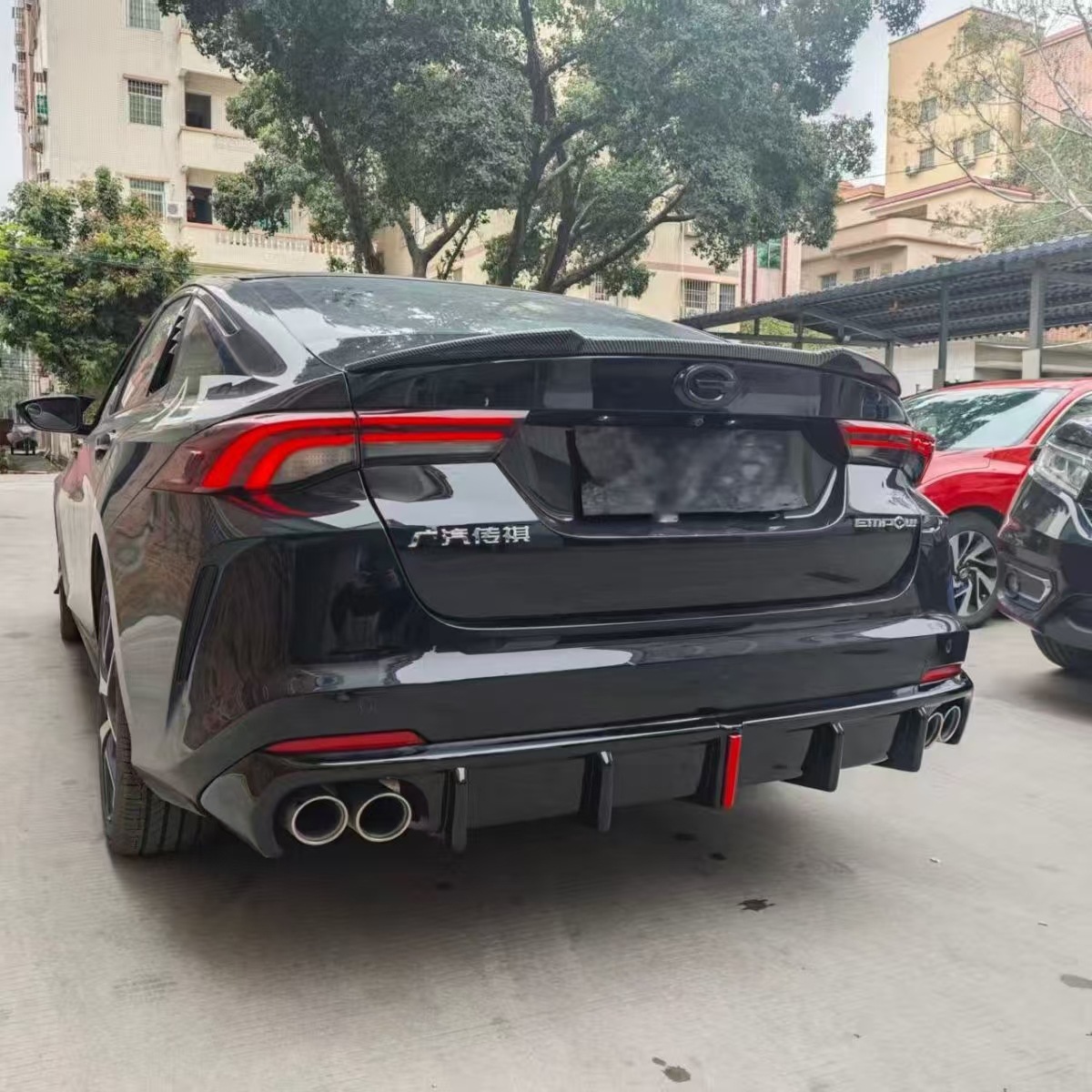 Suitable for 2021-2023 GAC Trumpchi Emkoo, modified with a large rear bumper lip, featuring a carbon fiber pattern and integrated lights, and a rear spoiler lower guard