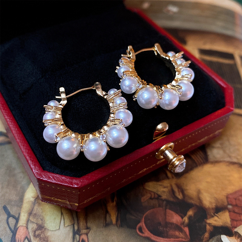 Pendientes de amor de perlas de lujo ligero con aguja de plata Pendientes de sentido de alta gama de temperamento de nicho Pendientes de estilo de palacio de todo fósforo de moda al por mayor