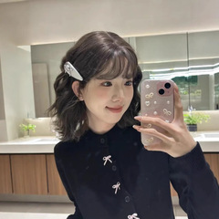 韓国系のデザイン感のある蝶結びの黒いニットのカーディガンの女性の秋冬のセーターのコートの高級感の中に底の上着を掛けます。