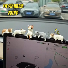 猫の車のスクリーンの小さい置物は車の中で制御して腹ばいになります。