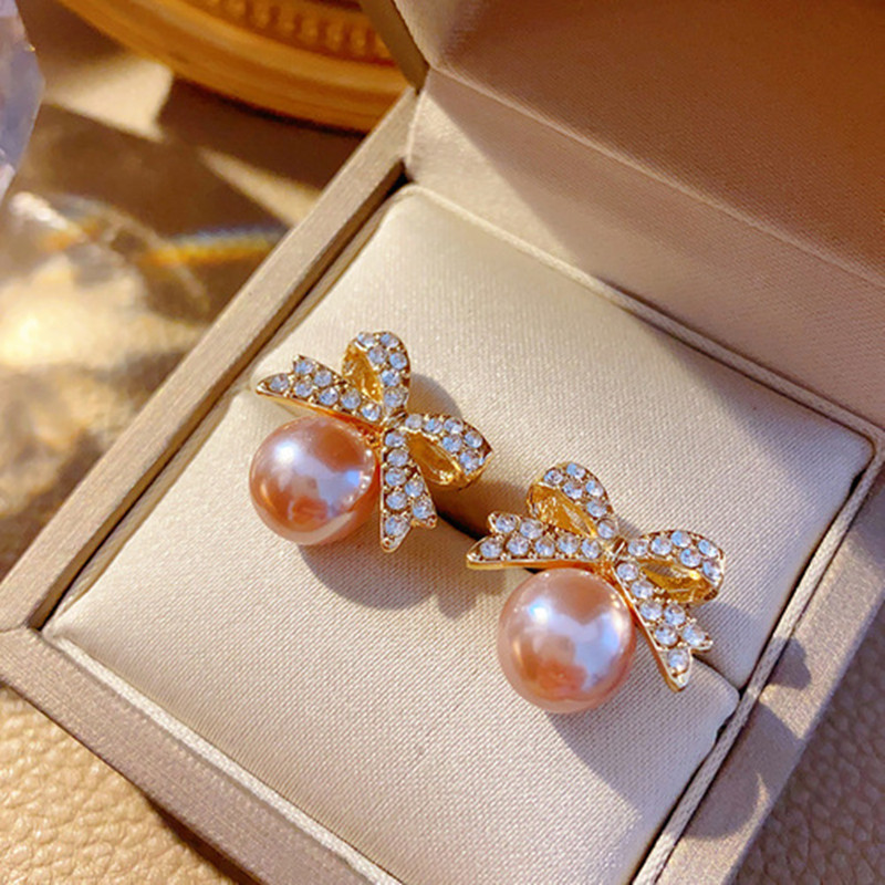 Design earrings with bow from pearl