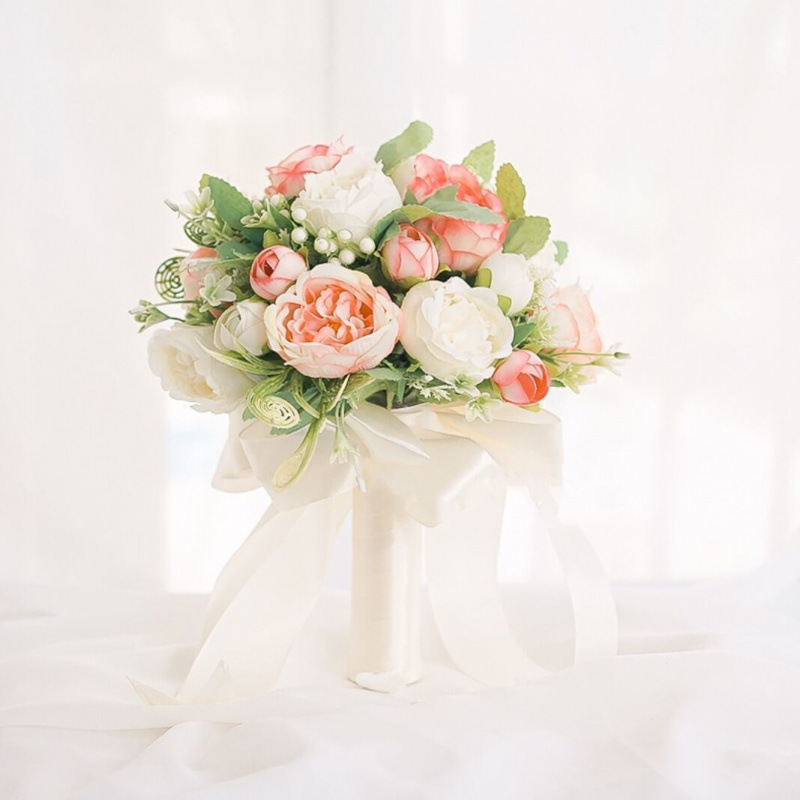 手に花を持つ新婦の韓国式結婚式の領収書のシミュレーションの花束の森系のウェディングドレスの撮影の道具の手に花をささげます。|undefined