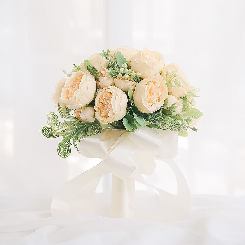 手に花を持つ新婦の韓国式結婚式の領収書のシミュレーションの花束の森系のウェディングドレスの撮影の道具の手に花をささげます。|undefined