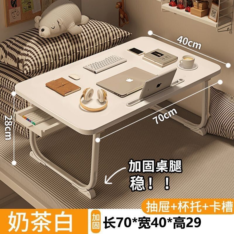 ベッドの上の小さい机のノートパソコンの机の上で折り畳みます。|undefined